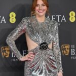 Bryce Dallas Howard Instagram - A magical night at the BAFTAs in London 🎭🪩⁣ ⁣ Hair: @cwoodhair ⁣ Makeup: @kaymontano⁣ Styled by Publicist Extraordinaire: @alex.schack 📸 1+6: @cwoodhair⁣ 📸 2-5: @gettyentertainment @BAFTA ⁣ #EEBAFTAs⁣ ⁣ [ID: Arriving on the red carpet with her hair in a relaxed up-do, BDH wears a silver sequined long-sleeve dress from @newarrivals.co with a cut-out around the waist ending with a black rose. Paired with the dress are a pair of black @maisonvalentino platform heels and a silver beaded bracelet & ring from @bulgari.]