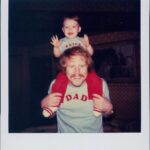 Bryce Dallas Howard Instagram - Happy 70th birthday Daddio! I love you SOOOOOOO MUCH!!!⁣ ⁣ [ID: A polaroid photo of a smiling Ron Howard and 1-year-old BDH who gleefully sits on his shoulders. They wear matching gray t-shirts – one with “BRYCE” and one with “DAD” on the front in block red letters.”]