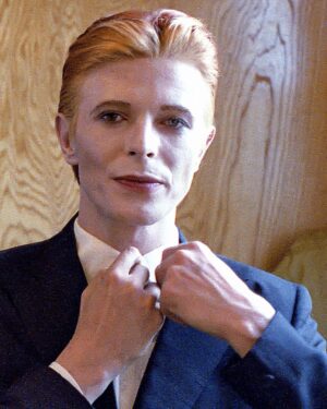 David Bowie Instagram - Not much evidence of a mirror in this first shot from 1975 of Bowie as Thomas Jerome Newton, until you look at those famous eyes.

All is revealed in the uncropped image as Geoff MacCormack is seen taking the shot in David’s changing room on the set of The Man Who Fell To Earth. 

Have you read Geoff’s book DAVID BOWIE: ROCK 'N' ROLL WITH ME?

It’s a touching account of a lifelong friendship, peppered with Geoff’s extraordinary shots of David at work, rest and play: https://bit.ly/RockNRollWithMeBook (Linktree in bio)

#BowieReflections