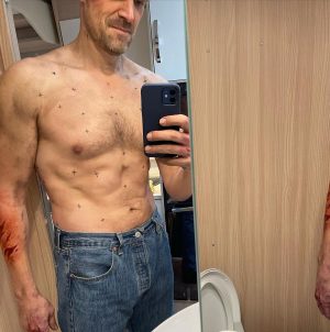 David Harbour Instagram - Many of you have asked about Hopper’s physical transformation from season 3 to season 4.  My trainer @davidhigginslondon worked with me for 8months to make the transformation, and then another year to keep it through the pandemic.  All told it was a difficult and exciting ride, changing diet and exercise plans (or lack thereof). We are gonna do an Instagram live tomorrow Friday at 4pm UK time, which is 11am eastern I believe.  Wanna answer questions you may have with @davidhigginslondon and tell you what I learned.  Second pic is me and David the week we began, my resistances and fury flaring.  And pic three is the shoot day, the black x’s are for cgi scarring because of problems with the practical effect.  All told I lost over 75lbs.  265-270 in season 3 and all the way down to 190 when we shot.  Recently ballooned up again to play jolly ole st. Nick in a flick I can’t wait for you to see this holiday season, so I am struggling to fight back down towards a good weight for wherever hopper ends up in season 5.  All this up and down is not good for the body, and I’ll have to give it up soon, but it is such a fun part of the job to live in a different version of your skin for a while.  Come join us tmrw for the live and bring qs