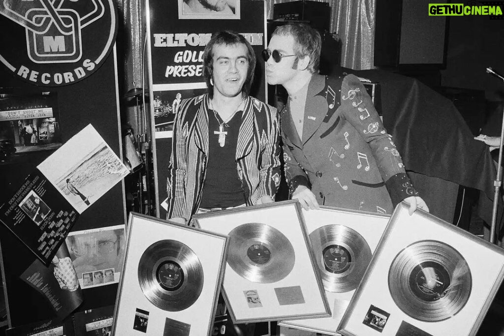 Elton John Instagram - ”Don't Shoot Me I'm Only The Piano Player” was our first No.1 record in the UK, and second in the US. Here is a photo of @bernietaupinofficial and me with some of our first gold records in 1973 (little did we know how great our collection would become). 📸@michaelputlandphotography