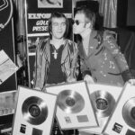 Elton John Instagram – ”Don’t Shoot Me I’m Only The Piano Player” was our first No.1 record in the UK, and second in the US. Here is a photo of @bernietaupinofficial and me with some of our first gold records in 1973 (little did we know how great our collection would become).

📸@michaelputlandphotography