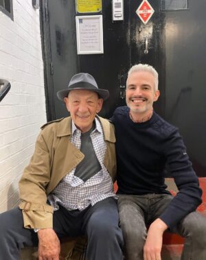 Ian McKellen Instagram - Frederic Aranda @fredericaranda is a London-based portrait photographer whose image of me went viral in 2019. His work has been featured in books and exhibitions, most recently at the National Portrait Gallery for the Taylor Wessing Portrait Prize. He's worked with the Royal Ballet, the Kabuki and puppet theatres in Japan, the RSC and the Passion Play in Oberammergau (on my recommendation). Recently he brought his camera backstage at "Mother Goose." We'll be posting some of the results in coming days. I'll let him take it from here, with a fascinating look behind the scenes of a photographer's process:
"I'm passionate about photographing people and have been doing it for 20 years. When I'm not shooting, I often dream about it at night — about how I would stage a group portrait for example, and what I'd capture of each person in it. I compose images in my head all the time.
"I'm very interested in what happens behind the scenes, peeking through the curtain or through a half open dressing room door. I love capturing the warm ups, the rising tension and the transformations backstage. I'm curious about how it all works. I admire all the wonderful people you never see on the stage who make it all fit together and work so smoothly. My approach has been to capture without directing, staging or meddling. I wanted them to pretend I wasn't there.
"Photographing Mother Goose backstage has been the most wonderful privilege. Not just because of the world class talent, but also because it's exactly the joyful balm that we all need right now. I laugh when I hear the jokes, no matter how many times I've heard them before. The songs are excellent too.
"During Mother Goose I loved photographing Ian's transformation in his dressing room and also his quick changes in the wings. It takes 3 or 4 people to get him in and out of costume each time, but in record time. Note that he's tap dancing on stage and doing all sorts of physical feats, and then has to come and get changed each time. There are some amazing moments from the wings behind some of the gauze-screens which really summarise the half on and off-stage feel that I wanted to capture."