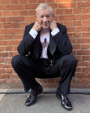 Ian McKellen Instagram - Wimbledon has the Centre Court and also the Theatre, where I first appeared in the pre-West End run of "A Scent of Flowers." I shared a dressing room with the late Peter Howell. There we were by the stage door, enjoying the late summer sun after a Wednesday matinée in 1964. https://mckellen.com/stage/00028b.htm Yesterday I was back on location at Wimbledon Theatre, by the same distinctive brick wall, after my first day filming Patrick Marber’s  screenplay "The Critic."