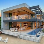 Jason Oppenheim Instagram - Just Listed - 2201 Bayside Dr. - $27,995,000 5 Beds / 9 Baths / 9,129 Sq. Ft. / 11,921 Lot Size This newly constructed custom estate offers exclusive Corona Del Mar waterfront living with intricate design touches and a harmonious blend of natural stone and wood elements. Consisting of 5 ensuite bedrooms and 9 bathrooms and boasting approximately 50 feet of private beachfront, it caters to water enthusiasts and offers shared ownership of one of the longest private docks on the west coast, capable of accommodating multiple yachts up to 100ft in length. Upon arrival, you will be greeted by meticulously landscaped surroundings, a striking grand pivot door, and a double height foyer that sets the tone for the residence. Inside, the space boasts European wide plank bleached oak flooring by Gaetano, illuminated floating staircases, and expansive glass features that fill the approximately 9,129 square feet of interiors with an abundance of natural light. The property seamlessly connects to its surroundings through slide-away pocket doors that open onto a heated patio, a zero-edge saltwater pool and spa, and a courtyard featuring a built-in Lynx Grill. The kitchen features custom Honed Calcatta Vagli slab countertops and backsplash, a 55" La Canche designer stove imported from Paris, a butler's pantry, and stained white oak cabinetry. Convenience is paramount, with a Waupaca elevator servicing all four floors, including the lower level, which encompasses a media area, a dry bar, and temperature controlled wine room. Upstairs, the owner's suite presents a heated wraparound balcony with mesmerizing water views, a living space with a fireplace, and two spa-like bathrooms, each complemented by its own walk-in closet. The top level reveals a lounge area that opens onto a rooftop deck with grass and sweeping views of the Newport Beach Harbor offering limitless ocean-view entertaining. Equipped with cutting-edge technology, the property also includes a nearly 3,000 sq. ft., 6+ car garage with epoxy flooring. Listed by @briancharlesfurstenfeld @mskaylacardona @jasonoppenheim Corona del Mar