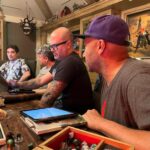 Joe Manganiello Instagram - Got the band back together after three years of remote play and no play… WAR OF DRAGONS Episode 73 kicked off with a food truck and a two hour recap from the very first adventure five years ago, all the way through to the present. The Sandal of Gygax made its appearance as it settled into its new home for the next calendar year at The E. Gary Gygax Memorial Dungeon in Beverly Park next to a set of Gary’s dice gifted to me by his son Luke for my 42nd birthday a few years back. Vince spearheaded a surprise for me, a framed piece of art by Max Dunbar that was used to craft the Wizkids miniatures sets, including all of the characters in the group but this time, with a looming Tiamat above. So f-ing cool… It was a blast seeing everyone in person! Can’t wait for the next session.