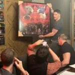 Joe Manganiello Instagram - Got the band back together after three years of remote play and no play… WAR OF DRAGONS Episode 73 kicked off with a food truck and a two hour recap from the very first adventure five years ago, all the way through to the present. The Sandal of Gygax made its appearance as it settled into its new home for the next calendar year at The E. Gary Gygax Memorial Dungeon in Beverly Park next to a set of Gary’s dice gifted to me by his son Luke for my 42nd birthday a few years back. Vince spearheaded a surprise for me, a framed piece of art by Max Dunbar that was used to craft the Wizkids miniatures sets, including all of the characters in the group but this time, with a looming Tiamat above. So f-ing cool… It was a blast seeing everyone in person! Can’t wait for the next session.