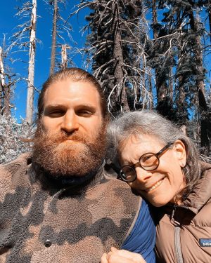 Keegan Allen Instagram - thinking of my mom on her birthday today. The beauty and grace she left remains along with her vacancy. It’s a soft pain I carry silently. But all is temporary except for love.

You don’t need to read the rest, I’m just venting.

It’s weird because it’s been a year, and I have only just begun to mourn. Sometimes it hits me all at once and sometimes it’s a light breeze. I’m still so disoriented in this version of outcome. I know there are so many people grieving different types of losses and grief and it’s complexities challenge us to go deeper into our own existence. 

Everything feels brutally incomplete without her. A deep friendship with my mother pulls me into heaven with her sometimes searching in dreams, listening to the wind, humming through the garden…unable to locate her I just accept reality. Everyone gives solace through quotes and guidances but it’s all a tool that doesn’t fit the job. My life with her was an epic journey, finished too soon. I live for her now but always reaching outside of the barriers.

Today, maybe just for a moment, look around and try and find a place to exist and appreciate that existence. We are all having a human experience, and that’s it. It’s a fleeting thing and we only have the gift of now. 

I miss my mom, absolutely and forever. I know she’s standing on the moon or off on some cosmic adventure. 

Or, maybe she’s finally a little mushroom growing by the stream, her dream. Sweet dreams in a cabin by the fireplace. The scent of red cedar and roses.