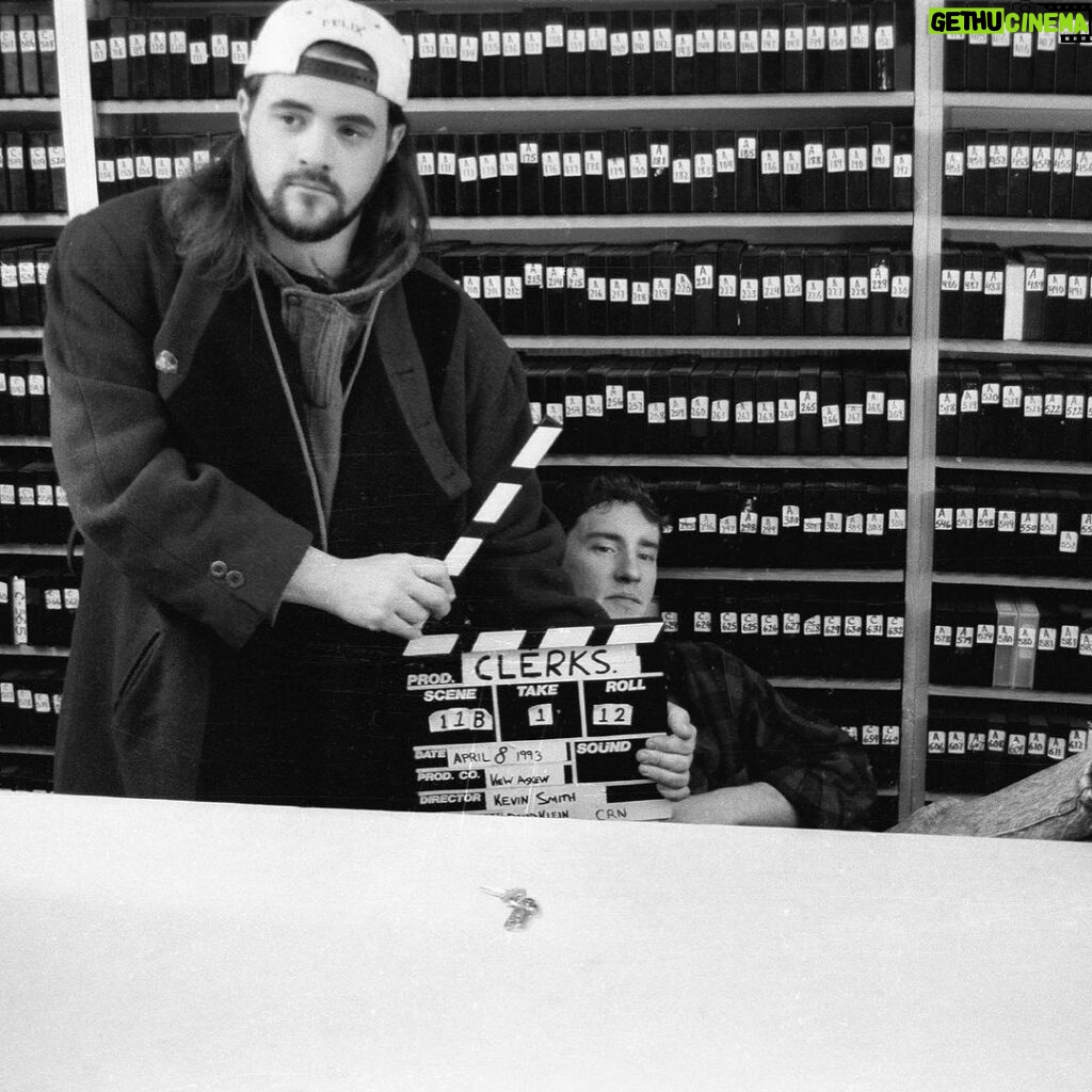 Kevin Smith Instagram - HAPPY CLERKS DAY! 30 years ago from today, CLERKS debuted at the 1994 Sundance Film Festival! That means, if you ever wanted to stop me or my career from happening, youʼd send a Terminator back to this moment in time 3 decades back. Mercifully, there was no robotic hunter/killer trying to kill me at Sundance that year. The inaugural screening took place at the Holiday Village Cinema in a sold out 150 seater. That was the first time I got to see my first film with a full audience. The sheer thrill of finding out that ideas Iʼd had years prior actually held up to public scrutiny from strangers was intoxicating (but that also might have had something to do with the thin air at the high altitude). That first screening started the buzz that powered the next three screenings and a deluge of press about the black and white New Jersey convenience store movie and the director who was going back to work there after the Festival ended. By our fourth and final Sundance screening at The Egyptian Theater on Main Street in Park City, Clerks was being talked about and written about like it was well worth watching. As he introduced me and the film, Festival head Geoff Gilmore described me in a way that still gets me in the feels when he said “If Kevin Smith didnʼt exist, the Sundance Film Festival wouldʼve had to invent him.” Mine was a Cinderella-ish or Rocky-like tale that reminded folks anyone can take a shot at their dreams and maybe find a modicum of success - even if theyʼre from New Jersey. Do you have a dream (one that doesnʼt involve hurting people or animals, destruction or death)? 2024 is the year you move closer to your goal and take your shot on yourself. Many thanks to Brian, Jeff, Jay, Marilyn, Lisa, Scott, Dave, Kim, Virginia, Donald, Mom, Dad, the Thapars, and everyone else who helped me craft Clerks! Many thanks to Sundance, Mark Tusk, Bob Hawk and John Pierson for guiding a gobsmacked newcomer in his sudden success. And many thanks to you, my friends, for 30 years of continued interest in the Askewniverse adventures of retailing rascals Head over to JayAndSilentBob dot com TODAY to shop our anniversary sales! #KevinSmith #clerks #film