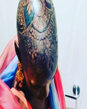 Lupita Nyong'o Instagram - THE STORY OF MY HEAD: 
I met @hennabysabeen last year at a wedding in Pakistan. She did the #HennaDesign for the bride and I was ASTOUNDED by the INTRICACY and BEAUTY of her work. There was something unique about the way she expressed herself in henna art. And I promised myself, "One day I will have a reason to work with Sabeen."
:
1.5 years later, when I got the invitation to attend the opening night of my dear friend, Mira Nair's @monsoonmusical, I was scrambling at the last minute to find something to wear. I borrowed a sari and jewelry from @mishajapanwala, the bride from Pakistan, but the look didn't feel complete...
:
And then, in the middle of the night, an image SHOT into my mind of a henna design covering my bald head!!! I could do something special and different, to celebrate the culture using the canvas readily available to me! I was so excited by the idea that I could not go back to sleep. Misha connected me to Sabeen, and we were ON OUR WAY...
:
Sabeen had NEVER designed for a head before; I had never done such a thing before either. My only prompt to her was that I wanted a widow's peak (homage to the bindhi, borla / maang tikka), the rest was ALL HER INNOVATION.  She suggested #jagua, a natural dye from the jagua fruit of South America that would be dark enough to give good contrast to my dark skin ☺️. 
:
We were both excited and terrified. What if it went wrong or looked funny??? Well, I thought, I can always wear a head wrap.... 
:
But Sabeen BROUGHT IT! We stopped now and again so that I could give her feedback because she was DETERMINED to leave me a happy client. And Sabeen was METICULOUS. She did not stop until it was perfect. When we looked at the finished head... we were both GRINNING!
:
It takes about 24 hours for the dye to really show up. And when it came in, in FULL CONTRAST the next day, I was simply MOVED. It was beautiful. It was bold and elegant; it had a point of view. We had not played it safe, and it had paid off. And I had found a new way to express myself without hair! 
:
So the moral of this story is: DARE YOURSELF TO SEEK OUT BEAUTY IN NEW WAYS. And, Sabeen, thank you for bestowing on me the beauty of your hand and history!