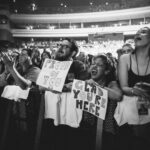 Macklemore Instagram - After a couple off days back in Seattle I landed in phoenix and was greeted by a sizzling 102 degree sun. I decided to dress up like a falcon wrangler. I met people outside that had been waiting since 9:30am to get in. We hugged, shed some tears and I felt really good in the spirit. The venue was air conditioned and dog friendly prolly. Just had that vibe that if you were a dog they’d let you chill in a hallway and give you a mini Mars bar or some shit. Anyway, I hit the stage in my falcon handling gloves and immediately felt restricted by the big tough leather covering my palms. After the first song they had to go. Bam! Threw them shits. The crowd was loose and nibble as was I, well hydrated and relatively sturdy. I was hitting a lot of spin moves to showcase how hydrated I actually was all while thinking in my head “You still got it my boy”. We laughed and some of my jokes hit. Some didn’t. Some people yawned. That always throws me off, so if you come to a show and you’re tired please hold that shit in. Anyway, the whole crowd was full of love and they sent us off stage with smiles and daps. Beautiful evening with the Cacti loving folks of Arizona. Next stop…LA for our finale show tonight.