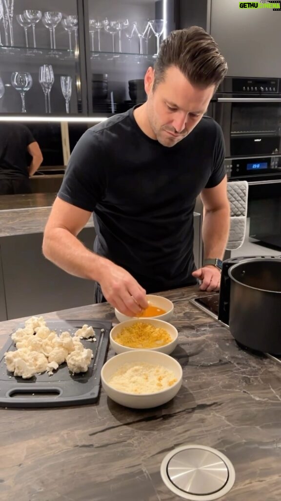 Mark Wright Instagram - Crispy, Parmesan Cauliflower with a Tortilla Crumb. Unreal🔥. Ingredients: (you can adapt this to suit the size of your cauliflower and how much you want to make but the below is based on half of a large cauliflower). - Half a large cauliflower - Half a cup of grated parmesan - 2 eggs, whisked - Handful of salted tortilla chips - 1/2 tsp garlic powder - 1/2 tsp paprika - Salt - Pepper - 1 tbsp mayo - 1 tsp hot sauce Method: 1. Prepare for cauliflower by taking off the leaves, then using a sharp knife cut in half and removing the hard stalk. You’ll be able to easily break the florets into bite size pieces with your hands. Wash then set aside. 2. Whizz your tortilla chips in a blender until crumb like, then add to a small bowl with your spices, salt and pepper. 3. In a second separate bowl whisk your eggs and in a third add your finely grated parmesan 4. Dip each floret into your egg mixture, then the tortilla crumb and finally the parmesan. 5. Air Fry for 15 minutes (turning every 5), meanwhile mix a tablespoon of mayo with some hot sauce for the best dipping sauce!