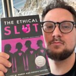 Matt McGorry Instagram - "The Ethical Sl🫦t" by Janet W. Hardy & Dossie Easton Where my polyamorous/non-monogamous ethical sl🔥ts at?? 🤗🥹🤗🥹 I’ve been polyamorous for a few years now and have read quite a few books about it. But this was the first book that I read that really started me on the path. The funny thing is, I had it on my bookshelf for years as I identified as monogamous but for some reason I never read it. Perhaps I subconsciously knew that it would start to open some doors for me that would change my life, and that there would be no going back from. And that somehow, I just didn't feel ready. There is nothing wrong with monogamy itself. The same way there is nothing wrong with heterosexuality. But the problem is where the compulsory aspects of it lie. For example, I do believe that a lot more people would explore and step outside of monogamy (and heterosexuality for that matter) if it were not so heavily stigmatized to do so. While the social norms are shifting, there is still much work to be done transforming the systems and cultural beliefs that shame, pressure and coerce people into thinking that monogamy is the only real viable choice. It's only been a couple of years since I realized that polyamory was for me and it took me most of that time to feel comfortable fully embracing it in a way where I would be okay with people knowing that about me, as a public figure. For me, reading is an essential piece of how I learn about new things that I'm passionate about. And because we don't often see examples of how to have conversations about these issues, it can feel really challenging to know where to start. I believe that is the magic of books. For those who don't feel comfortable just jumping into shit 🙋🏻‍♂️, it gives us the opportunity to get some clarity about our desires and to build the capacity, skills, and tools that allow us to express those needs. May we all work towards the courage of giving space for and identifying our deepest desires and being able to put them into words. My Booklist: bit.ly/mcgreads (link in bio) #McGReads