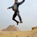 Mena Massoud Instagram - One from my bucket list! I’ve been to the Pyramids at Giza a few times now, but I’ve always wanted to go back and ride a horse through the desert with the wind at my back and the pyramids on the horizon. I got to do just that and man - it was breathtaking! The energy in Egypt is just incredible. Comment below your top bucket-list adventures. Give me some ideas people!
