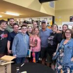 Mike Rowe Instagram – Sunday, outside of @BelAirLiquors there was thunder and lightning and an inch of rain falling every 30 minutes. Inside, there were over 100 well-mannered people with excellent taste in whiskey, waiting patiently in line to shake my hand and grab a photo. What do you say to people who brave a hurricane to say hello and buy a signed bottle of your grandfather’s whiskey? Well, if you’re me, you say “thanks,” as sincerely as you can, over and over again.

Among others was the Pelletier family, all 14 of them. This is the largest family I’ve ever posed for a photo with, and I’m not even sure they were all represented. Once you show up with 14, you have to assume there’s another 3 or 4 in the wings, right? I don’t remember each of their names, but I think it was young Jake (?) who made a crab out of stones, mounted it in a very tasteful frame, and presented it to me as a gift. Thanks, Jake. Very thoughtful. I’ll hang it in a place of prominence upon my return.

I met Nick Berte, who built a very cool Double Whiskey Barrel Liquor Cabinet, that opens and closes with the touch of a remote control. The store is raffling it off at the annual Maryland Italian Festival to raise money for charity.

I met Mike Griffith, who is a Maryland State Delegate for District 35B. I know this because he gave me his business card, which I I’ll hang on to. You never know when you need the services of a state delegate, right?

And then there was Jon, a Baltimore County Detective who was shot four times by a creep with an AR-15 just a few months ago. Jon survived, happily, and was released from the hospital not long ago. His wounds are very serious, but he stood in line like all the others, thanked me for supporting first responders, and gave me a patch that said, “Don’t Die Easy.”

What do you say to a guy who risks his life to serve and protect you, gets damn near killed, and then comes out on a rainy Sunday to shake your hand? If you’re me, you say “thanks,” as sincerely as you can, over and over again.

I proprietor, Larry Dean, and his hardworking family. Big thanks to all of you guys, for making it happen. And congratulations  for having such awesome customers.

Till next time. Belair Md