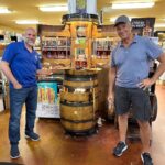 Mike Rowe Instagram – Sunday, outside of @BelAirLiquors there was thunder and lightning and an inch of rain falling every 30 minutes. Inside, there were over 100 well-mannered people with excellent taste in whiskey, waiting patiently in line to shake my hand and grab a photo. What do you say to people who brave a hurricane to say hello and buy a signed bottle of your grandfather’s whiskey? Well, if you’re me, you say “thanks,” as sincerely as you can, over and over again.

Among others was the Pelletier family, all 14 of them. This is the largest family I’ve ever posed for a photo with, and I’m not even sure they were all represented. Once you show up with 14, you have to assume there’s another 3 or 4 in the wings, right? I don’t remember each of their names, but I think it was young Jake (?) who made a crab out of stones, mounted it in a very tasteful frame, and presented it to me as a gift. Thanks, Jake. Very thoughtful. I’ll hang it in a place of prominence upon my return.

I met Nick Berte, who built a very cool Double Whiskey Barrel Liquor Cabinet, that opens and closes with the touch of a remote control. The store is raffling it off at the annual Maryland Italian Festival to raise money for charity.

I met Mike Griffith, who is a Maryland State Delegate for District 35B. I know this because he gave me his business card, which I I’ll hang on to. You never know when you need the services of a state delegate, right?

And then there was Jon, a Baltimore County Detective who was shot four times by a creep with an AR-15 just a few months ago. Jon survived, happily, and was released from the hospital not long ago. His wounds are very serious, but he stood in line like all the others, thanked me for supporting first responders, and gave me a patch that said, “Don’t Die Easy.”

What do you say to a guy who risks his life to serve and protect you, gets damn near killed, and then comes out on a rainy Sunday to shake your hand? If you’re me, you say “thanks,” as sincerely as you can, over and over again.

I proprietor, Larry Dean, and his hardworking family. Big thanks to all of you guys, for making it happen. And congratulations  for having such awesome customers.

Till next time. Belair Md