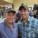 Mike Rowe Instagram – Sunday, outside of @BelAirLiquors there was thunder and lightning and an inch of rain falling every 30 minutes. Inside, there were over 100 well-mannered people with excellent taste in whiskey, waiting patiently in line to shake my hand and grab a photo. What do you say to people who brave a hurricane to say hello and buy a signed bottle of your grandfather’s whiskey? Well, if you’re me, you say “thanks,” as sincerely as you can, over and over again.

Among others was the Pelletier family, all 14 of them. This is the largest family I’ve ever posed for a photo with, and I’m not even sure they were all represented. Once you show up with 14, you have to assume there’s another 3 or 4 in the wings, right? I don’t remember each of their names, but I think it was young Jake (?) who made a crab out of stones, mounted it in a very tasteful frame, and presented it to me as a gift. Thanks, Jake. Very thoughtful. I’ll hang it in a place of prominence upon my return.

I met Nick Berte, who built a very cool Double Whiskey Barrel Liquor Cabinet, that opens and closes with the touch of a remote control. The store is raffling it off at the annual Maryland Italian Festival to raise money for charity.

I met Mike Griffith, who is a Maryland State Delegate for District 35B. I know this because he gave me his business card, which I I’ll hang on to. You never know when you need the services of a state delegate, right?

And then there was Jon, a Baltimore County Detective who was shot four times by a creep with an AR-15 just a few months ago. Jon survived, happily, and was released from the hospital not long ago. His wounds are very serious, but he stood in line like all the others, thanked me for supporting first responders, and gave me a patch that said, “Don’t Die Easy.”

What do you say to a guy who risks his life to serve and protect you, gets damn near killed, and then comes out on a rainy Sunday to shake your hand? If you’re me, you say “thanks,” as sincerely as you can, over and over again.

I proprietor, Larry Dean, and his hardworking family. Big thanks to all of you guys, for making it happen. And congratulations  for having such awesome customers.

Till next time. Belair Md