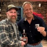 Mike Rowe Instagram – Big thanks to @drug_city_liquors in Dundalk for hosting a Meet and Greet. And an even bigger thanks to the 200 whiskey aficionados who grabbed a photo with yours truly, along with a signed bottle of Knobel Tennessee Whiskey. I was humbled, as always, by your presence, as well as your presents. Consider this cross-stitch from Amanda. Seriously, zoom and look closely at her handiwork. Amanda, aside from being a talented cross-stitcher, is a chemist, and a waitress. She told me that cross-stitching was cool again, and very relaxing. Maybe I’ll try it one day? But probably not, as I am not that cool.

Amy Cleaver wanted me to know we might be related. She brought a photo that featured a man she claimed was her Uncle Joe Hergenrather, who also happened to be my second cousin of mine, God rest his soul. Not that I doubted her, but after stopping by my parent’s place and consulting the extensive genealogical tome comprised by my Aunt Betty, it appears Amy was telling the truth. We are in fact related. Proving once again, you never know who you’re going to run into at a whiskey bottle signing.

Get a load of Gabe Brooks. Gabe is a former undercover cop in Baltimore who now works for the Bureau of Alcohol, Tobacco, and Firearms. I know this because he gave me an ATF Challenge Coin, and promised to make sure Knobel was properly registered. (It is.)

And then there was Bill Pearce. He then presented me with a terrific print from a local artist named Sam Robinson, who captured “The Manor Race,” one of the steeplechase races held every year in Monkton, which Bill’s family started 112 years ago. Bill knew my dad was having a birthday tomorrow, and that my mother was crazy for horses. So, he wanted them to have it, and asked me to give it to them with his regards. I did, and they were delighted. A lovely gift, on this, the 63rd anniversary of their nuptials.

So many other nice people, with so many stories to tell. Thanks for coming out, very much. If you couldn’t make it, you can order a bottle online, a portion benefits the @mikeroweWORKS. Link in bio.

Cheers! Dundalk, Maryland