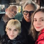 Selma Blair Instagram - 🤍🗽 Image Descriptions: 1. Selma has short blonde hair and is sitting on brick balcony wearing a grey coat with black collar. 2. Black/white photo of Selma and Christian Siriano at dinner. Christian has short dark hair and is wearing a black tshirt. 3. Selma is wearing a black sweater and sunglasses. A man is seated behind her playing with her dog Scout. 4. Black/white photo of Selma, Art Tavee and Carolyn Griffin at dinner. Art has short light hair and wears glasses and Carolyn has shoulder length hair. 5. Selma, Troy, Art, and Carolyn posing together for a selfie outside at dinner. 6. Selma posing in the mirror in a hotel bathroom. There are pink flowers in the focus of the photo. She wears a black sweater with a white collared shirt under it. New York, New York
