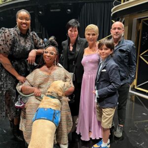 Selma Blair Instagram - About last night…💜

And all the love to @sashafarber1 and my crew of greats✨

IMAGE 1: Selma has short blonde hair and is being lead downstage into the spotlight by her partner Sasha who has short brown hair and is wearing a lavender suit.

IMAGE 2 : Selma has short blonde hair and is seated in a chair in wearing a long lavender dress while she looks to the left and holds hands with Amy, who has dark blonde hair and is wearing black pants and a black top.

IMAGE 3: Selma stands in a lavender dress with her friends Jamie, Andraéa, Hylda, her son Arthur and Jason.

IMAGE 4: Selma has short blond hair and is standing with her arm around her son Arthur, who is wearing a navy jacket.

IMAGE 5 - Selma and Sasha hug on stage at the end of their performance.