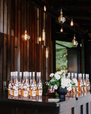 Taylor Lautner Instagram - COCKTAIL HOUR/RECEPTION
After the ceremony, guests were shuttled back down from the vineyard to the tasting room where they toasted one another with a glass of Casamigos cocktails named after our dogs Remi and Lily, and a variety of wines from Epoch. Live music was played on a grand piano covered in overgrown florals, and bottles of Epoch’s Rose were being live painted for guests to take home at the end of the night as a keepsake. Hundreds of Edison bulbs hung from the stunning trees over the cocktail bar, grand piano and live bottle painting station. On their way to the reception area, guests walked through a butterfly garden filled with greenery. There, butterflies floated amongst guests while a harpist played in the background. Once inside, there were candles from Snif burning a custom scent called “Sweet Ash” and leather menu books embossed with a custom TT logo at each place setting. We both attach smells to memories and people so we wanted to have a specific “scent” to our wedding that guests walked away resonating it to. We felt including this unique logo of two T’s intertwined (designed by our planner/designer Josiah) on just about every part of the day would make it feel special. Greenery and white florals filled the room to contrast the sexy industrial look of the tasting room. Did someone say more Edison bulbs? Yes, we did. Hanging Edison bulbs lined the three rows of tables we had for our loved ones. After our three course dinner paired with Epoch’s wines concluded everyone was ushered back outside surrounding the grand piano where our good friend and boy Tay’s groomsmen Aodhan King performed our first dance live. Aodhan and our other close friend Ben Hastings were gracious enough to lend us their beautiful voices for a few more songs until it was time to party. Low flying dry ice fog started to escape under the tasting room doors to outside inviting people back into a completely flipped dance floor that would take our souls for the rest of the evening. What’s a wedding without a dance floor, a few spilled drinks and the brides mother actually taking a nasty spill on it ;) (true story, rip to her kneecaps)