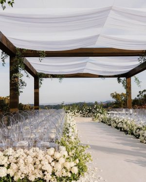 Taylor Lautner Instagram - CEREMONY
The ceremony was something we’ve been dreaming of for a long time. Along with the help of our wedding planners, we put in a lot of thought designing what exactly we wanted for this monumental moment and it came together even better than we had imagined. The ceremony location was at one of the highest points on the Epoch property which overlooks miles of wine country in Paso Robles. The colors surrounding us at this time of year are exactly why we love the Fall season so much. In an effort to provide shade and intimacy we installed a wooden truss system and semi sheer white draping, to create a relaxing and partially shaded ceremony location. White florals and lush greenery trailed up the columns of the wooden
structure and down the ceremony aisle. Beautiful white floral blooms surrounded us on a circle riser stage. As guests arrived by shuttle, they were invited to take a walk through the vineyard to the ceremony site. Our pastor and dear friend Judah Smith officiated the ceremony. It couldn’t have been more perfect. We exchanged hand written vows in front of the people we love most. Looking around and seeing the faces of each and every single person there, really put into perspective what is most important in life. Love. The sun set just as we said our “I Do’s” and the most beautiful pink sky was our backdrop as we walked back down the aisle as Mr. and Mrs. Taylor Lautner for the first time. 

Planning and Event Design @samkoma.world
Venue @epochwines
Photography @nicoleivanovphoto
Lighting @tn_event_designs
Floral Design @noonansdesigns 
Wedding Dress @winniecouture 
Grooms Tux @dolcegabbana