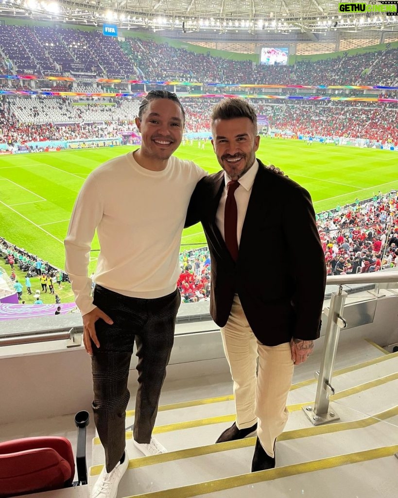 Trevor Noah Instagram - As a 15 year old I destroyed so many pairs of shoes trying to figure out how to bend the ball like this man. I never figured it out but yesterday he promised to buy me a new pair of predators😂. A true legend and absolute gentleman @davidbeckham #Qatar2022 #FIFAWorldCup Al Thumama Stadium