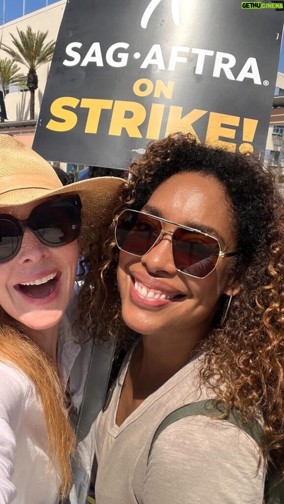 Sarah Rafferty Instagram - Reunited with my @iamginatorres on the picket line. There was a lot of kissing. And I will keep meeting her and kissing her on the picket line until we get a fair deal for all our @sagaftra (and @wgaeast @wgawest) brothers and sisters. Even though I chose to post the lighthearted bits…make no mistake, this is a fight for the dignity and future of our industry, the right to make a decent wage that is commensurate with our value to the business, the right to participate in the success of our work (I’m looking at you streamers who buy out our residuals and exclusively hold us for YEARS between seasons), the right to care for our families by earning enough to have health coverage (again with the erasure of residuals and ever shorter seasons and longer contractual holds keeping us hostage without the freedom to seek other work), and the right to create a path forward for future generations (how ‘bout when actors are “relocated”, even tho you know we can’t relocate full time to Canada for example, we simply receive adequate financial support in temporarily moving our lives abroad, and reasonable guard rails against a future where our work and likeness is fed to AI and used without consent and compensation). Our solidarity is stronger than their corporate greed. #unionstrong #sagaftra