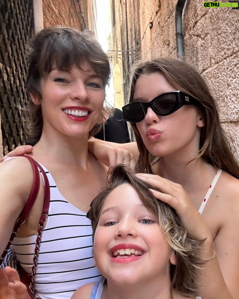 Milla Jovovich Instagram - I’m so excited to have been invited to attend the @amfar event and help raise money for this cherished cause in Venice, Italy! It’s been a healthy decade I haven’t been to Venice and it’s such a dream coming back here. Riding from the airport in a water taxi, watching the delicate, medieval city, opening up before me in such a calming and soothing way after a long and sleepless flight. The feel of the boat rocking underneath me is already getting me prepared for delights to come. We float on the water and get dropped at our hotel, which is a thousand year old monastery that was actually abandoned for over one hundred years before it got renovated into a hotel.  A bit on the spooky side, but I’m totally in to see some ghosts, hands down!  The light is so gorgeous everywhere that even with no sleep on the flight (I started playing Baldur’s Gate 3🤯 and I wasn’t about to have something as pesky as sleep stop me from jumping down that rabbit hole😂 ) I just put on minimal make up, tinted sunscreen, mascara, spf lipstick, I feel red carpet ready! This light ignores signs of jet lag and literally gives you a wink and secretly hands you 5 years back without even asking for a thank you. We’re only here for a few days, @everanderson is here working with the wonderful team @miumiu, doing her thing  and we brought our little Dash with us so we could make her feel grown up and special. It’s hard to give all three of my girls proper mama time when our 3 year old , Osian, is around. She’s just a mighty force of nature that demands absolute and undivided attention and the more you give, you know it’s only enough when your essence has completely disappeared into her own. She’s a smart kid😂. Goes without saying that we’re having a blast! I’ll go through more photos and do a nice dump when I get home! Thank you @amfar again for believing in me and having me here to support you for so many amazing years and thank you @miumiu for always taking care of my incredible young woman, my heart, Ever. ❤️🧨💥✨✨✨