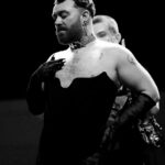 Vivienne Westwood Instagram - BEHIND THE SCENES: Echoing the ‘Blackout’ theme, @samsmith ‘s bespoke Vivienne Westwood show looks are presented in shades and textures of black.⁠
⁠
For the opening look, Sam appears in a double-breasted cropped jacket with braided epaulettes and aiguillettes worn with sailor trousers.⁠
⁠
Later in the show Sam reveals a corseted bodice paired with our iconic SEX choker and spiral lace gloves with claws.