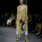 Vivienne Westwood Instagram - 'She had a very special relationship to time, she truly travelled in her mind' – Andreas on Vivienne.⁠
⁠
Look #18 from the Andreas Kronthaler for Vivienne Westwood Spring-Summer 2024 collection, featuring elevated platforms, styled alongside a small show tote bag, and the Calypso Dress in sequin cotton lace.⁠
⁠
#AKVWSS24