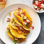 Martha Stewart Instagram - For an a-maize-ing upgrade, this easy dinner recipe has you quickly fry soft corn tortillas in hot oil just until their edges are crisp. This turns them into a crispy handheld treat filled with a hearty mix of shredded chicken thighs and a quick homemade tomato salsa. Get the recipe at the link in our bio. 📷: @paolaandmurray recipe: @lucullanfoods food styling: @brooklyncooks prop styling: @suzie_myers