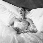 Vivienne Westwood Instagram - The Eline gown offers an unwavering sense of romanticism, embroidered with a Flora motif, taken from an archival couture lace. ⁠
⁠
The dress features a voluminous skirt with panniers, along with a straight neckline and transparent boned low hip corset bodice, accentuating the waistline. ⁠
⁠
The look is styled with fingerless gloves, echoing the decorative  detail of the dress. ⁠
⁠
Photography by @kingsley_ifill⁠
Styling by @florahuddart⁠
Talent: @elinehoyois⁠
⁠
#VWBridal #WestwoodBridal