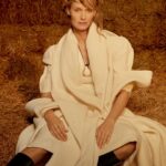 Amber Valletta Instagram – “I turn 50 this February, meaning I’ve worked in fashion for 35 years, and I’ve been a sustainability advocate for more than 20 of those, but in 2023 I hit a wall, mentally and physically,” confesses @AmberValletta. “The news just felt relentlessly bad – environmental and otherwise. I knew that, if I was ever going to get back on my feet, I needed to find a more sustainable approach to sustainability work.” In the January 2024 issue of #BritishVogue, the model and climate advocate reveals her path towards a more conscious future – and how fashion is following her. Click the link in bio to read the interview and see the full story in the new issue, on newsstands Tuesday 19 December.

#AmberValletta photographed by @CharlotteMWales and styled by @PoppyKain, with hair by #ShingoShibata, make-up by #KanakoTakase, nails by @TrishLomax, set design by @MaxBellhouse, movement director by @EricVonChristison and production by @FaragoProjects.

[Image one shows Amber Valletta, a white woman, from the knees up, sitting in front of a haystack in what appears to be a barn. She looks directly at the camera, her blonde hair loosely tied up, and wears a white mid-length dress underneath a white cape with a white scarf tied around her neck. A large gold pendant, roughly the shape of a horseshoe, hangs at her sternum on a leather chain.

Image two shows a full-length portrait of Amber Valletta, a white woman, in a clearing, a forest visible in the background behind her, looking directly at the camera. She is standing with her legs slightly splayed and wears a wide-brimmed dark brown hat, a ribbon tied around its crown. She has a pair of khaki trousers on, while a light pink collared shirt peeks out of the top of her brown trench coat, whose belt is tied insouciantly at her waist.

Image three shows a full-length portrait of Amber Valletta, a white woman, standing in front of a pile of kindling and firewood. She wears a quilted floral sleeveless coat liner with an oversized zip over a silver metallic gown. The wind is blowing locks of her shoulder-length blonde hair across her face, and her right arm rests casually on a piece of wood.]