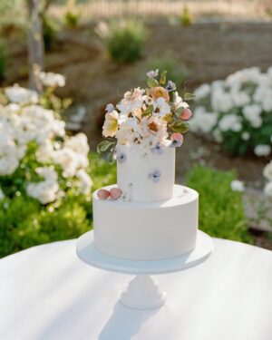 Arielle Vandenberg Instagram - I’ve always dreamed of having an intimate, backyard wedding! And two of our best friends, graciously offered their home! We wanted our wedding to be simple and sweet! And that’s exactly how it was! Bright and delicate flowers sprinkled across the tables. It definitely helped that the entire backyard had white roses in full bloom! (Gods gift saved us thousands of dollars lol). We had a deliciously unique cake that tasted of tres leches and apricot 🤤 (hands down favorite cake I’ve ever had). I’ve always wanted pizza at my wedding, so we hauled a 500 lbs pizza oven into the backyard for fresh amazing pizza! (Should have ate more that night, that’s for sure. 😂) Everyone took home Cutie cookies painted like our favorite girl, Stinky! Love was in the air as the fairy lights above our heads twinkled in the night sky and we danced the night away! ✨

Photos: @christinamcneill 
Video: @whiteinrevery 
Coordinator: @carlyraeweddings 
Dress: @chosenbykyha via @enblanc_la 
Veil: @amsale 
Glam: @afton 
Suit: @paulsmithdesign 
Catering: @madeinitalybistro 
Florals: @floretfloral 
Music: @rickyrocksdrums 
Cake: @kellygraycakes 
Cookies: @cubandcuppy 
Rentals: @lapinataparty 
Venue: @thejasonkennedy @thelaurenkennedy backyard 😍