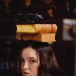 Bella Ramsey Instagram - Books are supposed to go on heads and Bella’s are supposed to go on postboxes and glasses are supposed to go on books on heads and then there’s a tortoise. Thank you Vanity Fair and friends. 🐢🙆🏻🎩📚🕶️