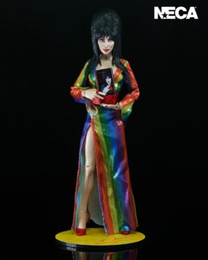 Cassandra Peterson Instagram - ANNOUNCEMENT! 🏳️‍🌈 🖤
➖
Elvira - Over the Rainbow Elvira 8” Clothed Figure 
➖
Celebrate Pride Month with Elvira, Mistress of the Dark! The devilishly delightful Cassandra Peterson has played the part of Elvira for more than 40 years with grace, humor and more than a little camp. NECA is proud to present this “Over the Rainbow” Elvira figure, celebrating the horror and queer icon in a never-before-seen, sparkling rainbow dress for your collection. With an original tailored fabric gown, glittery ruby red heels, and a yellow brick display base, she’s definitely not in Kansas anymore! This fully articulated 8-inch action figure features new faceplate technology with two interchangeable expressions and hands, including brand new ones that allow you to recreate Elvira’s signature pose! She comes with a book accessory of Peterson’s memoir, “Yours Cruelly, Elvira”, and a double-sided flag with 10 stickers to customize and show your unique pride! 
➖
Available now on thenecastore.com, and shipping to your favorite NECA retailer in June!
➖
#Elvira #MistressoftheDark #Pride #OvertheRainbow #CassandraPeterson #NECA  #actionfigure
