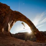 Chris Burkard Instagram - The Corona Arch in Utah has a quiet history of intrepid individuals like Tim Martin who decided to thread the needle in sense in a Cessna - flying through the arch despite it being 140ft wide and 105ft tall…not much margin for error & now illegal since designated a National Recreation Trail in 2018. Several years back, @sonyalpha commissioned me to shoot a project as part of the release of the A7RIII - so I put together a special production crew to push the limits of the camera among the canyons of Utah and see how we could display the ability for capturing vast landscapes & action sports in the same click of a shutter. After somewhat of an arduous permit process - I was allowed to have someone fly underneath the iconic arch and resulted in a special series of images I hope are a tribute in a small way to all of the undocumented pilots who flew underneath…
