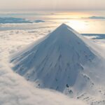 Chris Burkard Instagram – Stretching between the shores of Alaska and Russia, this chain of 14 volcanoes and 55 smaller land masses make up what is known as the Aleutian Islands… one of the most remote and difficult landscapes I’ve photographed –  due to the harsh storms the frequent the Bering sea that often shrouds them in thick clouds & fog. In the past, I had set out to these islands with the goal of surfing in mind.. but in 2018, I received a grant from Conservation International to document the Alaska Maritime Wildlife Refuge – focusing more on showing the scope of the landscape and it’s largely undisturbed beauty. 
We caught a window in the weather – so I grabbed my camera & jumped in a small plane… resulting in some of the most unforgettable aerial views of my career.