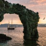 Chris Burkard Instagram - Iceland summer nights like these - exploring under midnight sun, makes the memory of long dark winter days quickly fade… In 2016 we sailed around the Westfjords for a week through the Greenland sea, hiking and kayaking through remote fjords…. Sometimes waking up around 8pm to hike and soak in as much of the landscape since the sun was still beaming down from above. On the last day we came to this natural rock arch... as the sun got low around 1am we had the idea to jump off this thing.. I had to follow suit. Jumping into that cold water (sans clothes) and swimming to shore was an experience I’ll never forget. I was shaking on the edge of that cliff despite the warm summer temps… scared to make the leap. One of those memories that inevitably brings a smile on my face