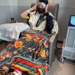 Grace Helbig Instagram - Scenes from chemo round 5! We’re officially 5/6th of the way through chemo!!! I can’t even process that right now, it’s all been so surreal. I brought this hat gifted to me by a friend of @mametown’s for a lil photo shoot. (If you listen to TMGW you know!) @elliottmorgan thought it was maybe “too dark” of a joke. Maybe he’s right, but I’ve lost my baseline for what’s normal or appropriate or “real life” at the moment so we’re just having fun! 5 infusions down! The adorable horrors of recovery await but we’re fucking doing it! 💪🏻🙃 #aintdeadyet