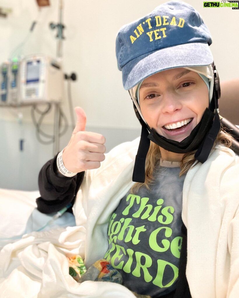 Grace Helbig Instagram - Scenes from chemo round 5! We’re officially 5/6th of the way through chemo!!! I can’t even process that right now, it’s all been so surreal. I brought this hat gifted to me by a friend of @mametown’s for a lil photo shoot. (If you listen to TMGW you know!) @elliottmorgan thought it was maybe “too dark” of a joke. Maybe he’s right, but I’ve lost my baseline for what’s normal or appropriate or “real life” at the moment so we’re just having fun! 5 infusions down! The adorable horrors of recovery await but we’re fucking doing it! 💪🏻🙃 #aintdeadyet