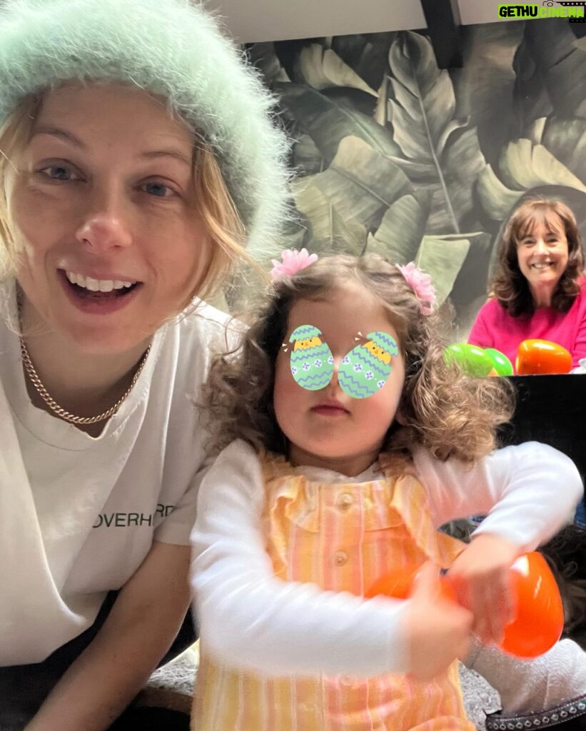 Iliza Shlesinger Instagram - We are Jewish but Sierra’s LA Grandma isn’t which means she gets Easter (and an Easter basket! I’m so jealous 🤍) and we all get Christmas. We filled eggs with Easter “candy” like… raisins and cashews and dried peaches and she had the best time. We did the neighborhood egg hunt too but she didn’t eat the chocolate because Mommy, who never lies, told her it was too spicy. Highlight for me was her holding this little blue bunny so delicately like it was a baby. Nothing will beat last year’s Easter outfit (last slide) but this one came close. 🐣🐰