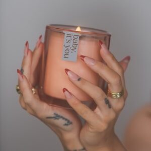 JoJo Instagram - Indulge your senses in my latest limited-edition offering, 𝘗𝘳𝘰𝘴𝘦𝘤𝘤𝘰 𝘗𝘢𝘭𝘰 𝘚𝘢𝘯𝘵𝘰 aka *baby, it’s you*. We combined some of my favorite scents to make a truly sexxyyyy candle. Encapsulated in a coconut soy wax massage oil blend (yes you can use it on your body, baby!) are top notes of sweet amber, dry prosecco, and palo santo. Middle notes are clove, Lilly of the Valley, and a touch of citrus. Grounding base notes evoke a rich mahogany and musk. We are featuring a gorgeous hand- chosen and cleansed sardonyx or apricot agate stone. Sardonyx promotes stability, protection, and happiness. It can attract friends and good fortune and is also known to increase stamina, vigor, and self-control. All important characteristics to employ whether you’re on a self-love journey or in a partnership. Apricot agate is a powerful yet gentle crystal which brings harmony to your energy as well as strength, vitality, and stamina. Our translucent desert rose- colored vessel is reusable and I encourage you to enjoy both the stone and the vessel long after the wax has melted. link in bio ✨🕯️