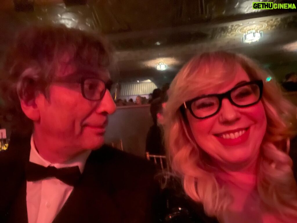 Kirsten Vangsness Instagram - My arm candy (not really, I find our friendship very nutritious, he’s more like arm mushrooms and I was his guest so that makes me the mushrooms) @neilhimself was wearing THE COOLEST SUIT while being his lovely self and being honored for being THE COOLEST CREATIVE @theartofelysium Neil Gaiman’s Heaven twas true nerd heaven- the set was a library and people read from books and genius @jeremyoharris was our librarian for the evening. @theartofelysium is doing extraordinary things using the arts to create heart opening experiences for folks in our most vulnerable communities, it’s a lovely place to volunteer and give to and I was happy to learn of them this evening.
