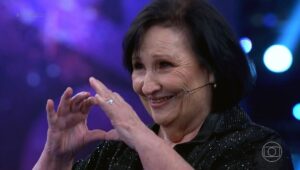 Maíra Azevedo Instagram - Ela é irreverente! Fala de amor, de conquistas de crush, fazendo muita gente  reconhecer que existe desejo após os 60 anos! Dona Déa traz a tona várias pautas apenas com sua presença no palco do @domingao … Ela traz o riso, mas conhece a dor e o choro! A sua história no cinema fez o Brasil se encantar com um mãe que dava o puxão de orelha, mas que também iria para guerra por conta dos seus filhos! Paulo Gustavo deu vida a Dona Hermínia, a mãe que todo mundo se reconhecia ou conhecia! Depois, a sua história da vida real fez o Brasil todo chorar! Dona @dealucia66 começou a carreira cantando em barzinhos e festas e aprendeu logo cedo que o show tem que continuar! Não se enganem, tem gente que não quer discordar, quer encontrar uma forma de silenciar …mas não vão conseguir…Dona Déa foi imortalizada pelo próprio filho, que não está mais aqui, mas com certeza está atento ao que fazem com sua mãe, e isso não é uma peça, é um show de horrores! Todo respeito a Dona Déa!