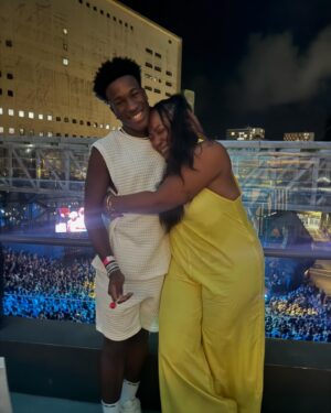 Maíra Azevedo Instagram - Meu melhor amigo saiu do meu ventre, foi no mês das mães que ele nasceu…para ser sempre meu presente! Há uma semana do seu aniversário, tivemos a oportunidade de assistir um show de @emicida juntos! Chorei em vários momentos…de nostalgia, da época que a gente comia soja como proteína, pq a grana não dava para comprar carne, mas a gente se alimentava também de esperança, de BOA ESPERANÇA! Ele pedia para assistir esse clipe de Emicida sempre que chegava da escola…e passou a ser d fã…A gente ouvia a trilha no caminho da Escola que ele estudava…e em pouco tempo MANDUME assou a ser a nossa música. Tipo aqueles códigos de amigos…Mandume é nossa trilha de vitória, de conquistas de realizações…que reafirma nosso Elo, que é amarelo, mas tem tb outras cores. A gente sabe que tudo que a gente tem é nós, por isso a gente se fala no olhar…aprendo tanto com ele…temos conversas difíceis, mas sempre digo LEVANTA E ANDA….pq eu sou sua MÃE e irei com você para MADAGASCAR ou para qualquer outro lugar…pq a nossa história…só a gente sabe! Me tornei aquela mãe boba…sempre que encontro @fiotioficial e @drikbarbosa eu fazia questão de falar da importância da música pra gente…a minha história com meu filho é de resistência e a música de Emicida, muitas vezes, aliviou nossas dores e nos deu a certeza que iríamos ter um futuro e hoje podemos voltar para nossa quebrada de mãos e mentes cheias…porque o correto é partir, voltar e repartir…a gente faz isso! Te amo meu filho @aladekoman