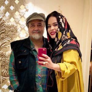 Melika Sharifinia Instagram - ا
بهترین معلم زندگی من 
تولدت مبارک ♥️
@mohamadrezasharifinia 
ا
بچه بودم شاید ۶ یا ۷ سالم بود 
مامان بابام‌ داشتن باهم صحبت می‌کردن 
مهراوه هم خودشو زده بود به خواب که از دست من راحت باشه! 
آخر صحبت‌شو‌ن بابام گفت برای بعضی‌ها همیشه مرغ همسایه غازه!
گفتم: بابا مرغ همسایه غازه یعنی چی؟ 
کلا بچه‌ی کنجاوی بودم، ولی مهم‌ترین دلیل اون سوال این بود که عاشق حیوونا بودم و برام جالب بود که یک مرغی هست که می‌تونه برای یک نفر دیگه غاز بشه! آخه خودم هم یه جوجه داشتم که یهو مرغ شده بود! بعد از یه مدت هم کاشف به عمل اومد که خروس شده!! البته من همون موقع هم منتظر بودم که بعدش غاز بشه و زودتر براش تولد بگیرم که دیگه بره به سمت «قو» شدن، ولی هیچ‌وقت غاز  نشد که نشد و ا‌ون‌قدر قوقولی‌قوقو کرد که مامانم اینا مجبور شدن ببرنش همون مزرعه‌ای که حیوونا می‌رن و خیلی خوشبخت می‌شن!! خلاصه اون موقع چون فقط تا قسمت خروس شدن ماجرا رو دیده بودم از بابام پرسیدم، اونم به جای این‌که برام توضیح بده، گفت: به نظر خودت یعنی چی؟ اگر معنیش رو درست بگی جایزه داری! منم که اسم جایزه می‌اومد سر از پا نمی‌شناختم، یک ساعت تمام هر آنچه به ذهن کودکانه‌م می‌رسید رو گفتم ولی موفق نشدم
بعد که بابام برام توضیح داد خیلی تعجب کردم‌
چون خیلی کوچیک بودم و در زندگی ساده‌‌ی خودمون با همچین حسی مواجه نشده بودم، ما همیشه به چیزی که داشتیم قانع بودیم و چیزهایی که دیگران داشتن برای ما مساله نبود
مساله‌ی پدر و مادر من همیشه چیزهایی بود که دیگران نداشتن و فعالیت‌هاشون در راستای ایجاد آرامش و رفاه نسبی در زندگی اون آدم‌ها بود
این‌ها رو بعد از این‌که بابام برام دلیل ندونستنم رو توضیح داد درک کردم و خیالم راحت شد، چون پیش خودم فکر کرده بودم خنگ‌ترین دختر جهانم! ولی ماجرا عمیق تر از این حرف‌ها بود و ربطی به هوش من نداشت، ربط به بستر درستی داشت که درش پرورش یافته بودم 
ربط به هم‌نشین نشدن با آدم‌هایی داشت که براشون مرغ همسایه غاز بود! چون مرغ همسایه برای ما همیشه مرغ بود و آدم‌هایی با این دیدگاه از زندگی ما دور بودن
تا من و مهراوه این موضوع رو از اونها یاد نگیریم
تا ما حتی درکش نکنیم 
تا همیشه در امان بمونیم 
از این‌ چشم‌و‌‌هم‌چشمی‌ها 
تا باور داشته باشیم، به خودمون 
قانع باشیم، به دارایی‌ اندک‌مون
و واقف باشیم، به ارزش وجودی‌مون 
که هرگز با هیچ‌چیز و هیچ‌کس 
قابل مقایسه نخواهد بود
اون شب 
من جایزه‌ای نگرفتم 
اون شب 
مرغ همسایه 
برای من «غاز» نشد
بلکه یک «فانوس» روشن شد 
در آستانه‌ی ورود کودکانه‌ام 
به جهانِ تاریک
آدم بزرگ‌ها!‌