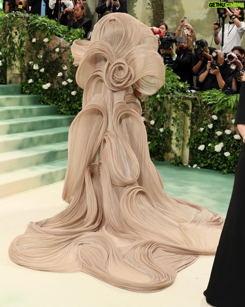 Mindy Kaling Instagram - The name of my gown was “The Melting Flower of Time”. I was so honored to wear the genius @gauravguptaofficial to the Met Gala this year. The cape was inspired by a blooming flower, and his signature sculptural techniques evoked the passage of time. Thank you Gaurav, @voguemagazine and the team of artists who designed my look! 🤍🤍🤍 📸: @gettyentertainment