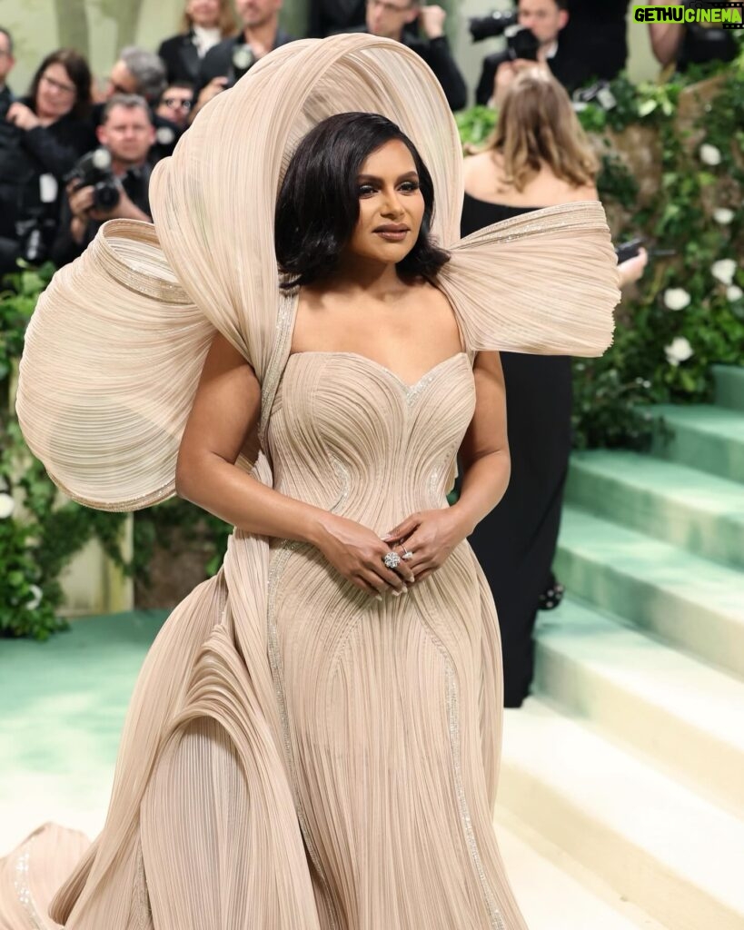 Mindy Kaling Instagram - The name of my gown was “The Melting Flower of Time”. I was so honored to wear the genius @gauravguptaofficial to the Met Gala this year. The cape was inspired by a blooming flower, and his signature sculptural techniques evoked the passage of time. Thank you Gaurav, @voguemagazine and the team of artists who designed my look! 🤍🤍🤍 📸: @gettyentertainment